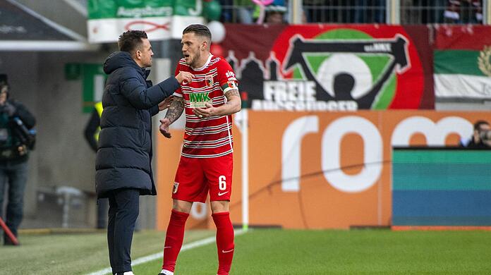Augsburgs Trainer Enrico Maaßen (l) spricht mit Jeffrey Gouweleeuw.