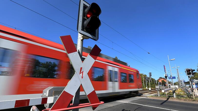 Eine S-Bahn fährt über einen beschrankten Bahnübergang. (Symbolbild)