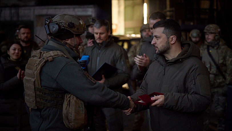 Auf diesem vom Pressebüro des ukrainischen Präsidenten zur Verfügung gestellten Foto zeichnet Wolodymyr Selensky (r), Präsident der Ukraine, einen Soldaten am Ort der schwersten Kämpfe aus.