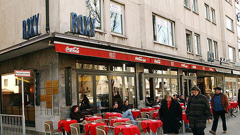 Das Café Roxy in der Leopoldstraße 48. Selbst an einem kühlen Herbsttag sitzen viele Gäste draußen auf der Freischankfläche und betrachten das Treiben vor ihnen.