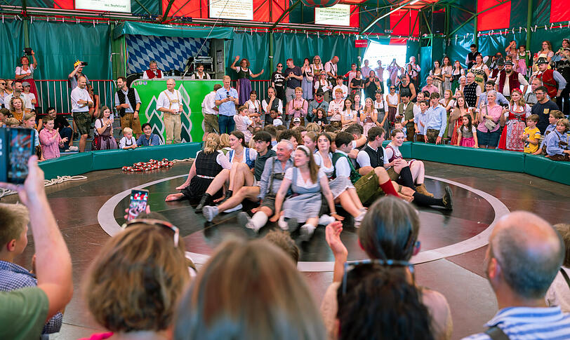 Besucherinnen und Besucher sitzen auf dem Teufelsrad auf dem Oktoberfest.
