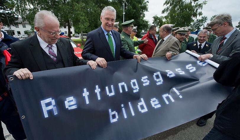 Innenminister Joachim Herrmann (M.) wirbt mit einem Plakat mit der Aufschrift &bdquo;Rettungsgasse bilden!&ldquo;