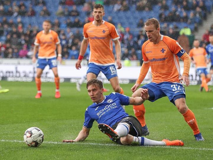 Bielefelds Joan Simun Edmundsson (unten) im Kampf um den Ball mit Darmstadts Fabian Holland (r).