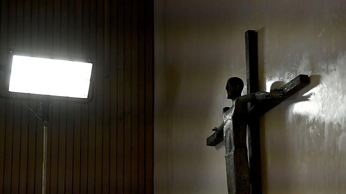 Ein Kreuz hängt an der Wand.
