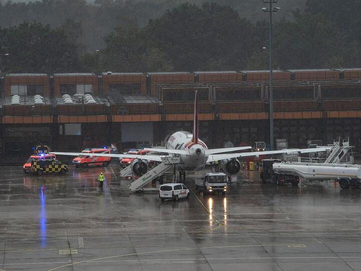 Einsatzfahrzeuge der Feuerwehr stehen neben der Eurowings-Maschine am Berliner Flughafen Tegel.
