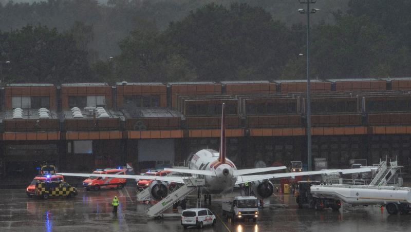 Einsatzfahrzeuge der Feuerwehr stehen neben der Eurowings-Maschine am Berliner Flughafen Tegel.