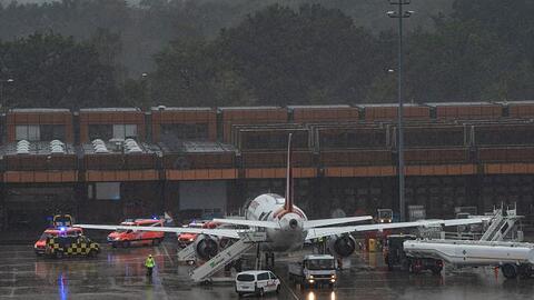 Einsatzfahrzeuge der Feuerwehr stehen neben der Eurowings-Maschine am Berliner Flughafen Tegel.