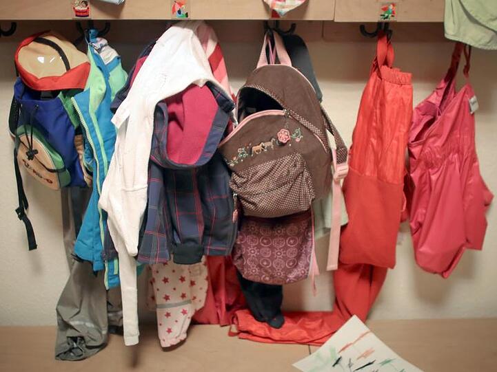 Jacken und Rucksäcke von Kindern hängen in einer Kita. Foto: Fredrik von Erichsen/dpa/Archivbild