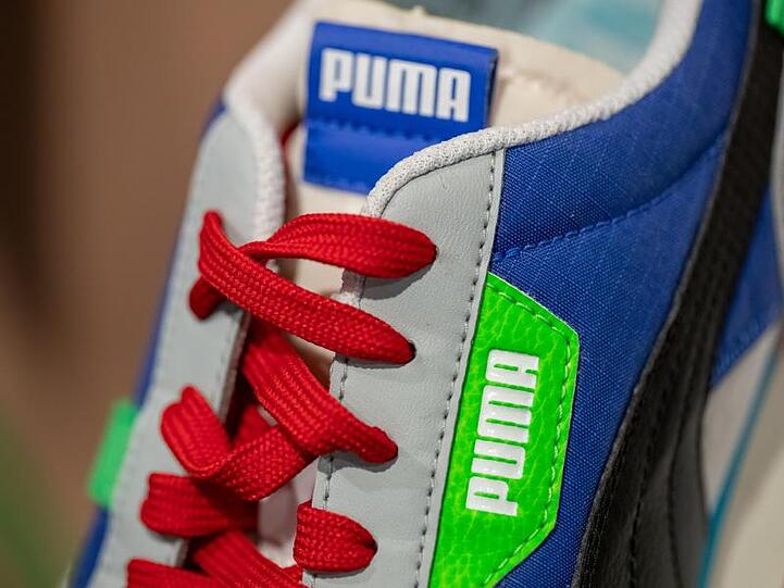 Ein Schuh des Sportartikelherstellers Puma ist am Rande der Bilanz-Pressekonferenz ausgestellt. Foto: Daniel Karmann/dpa/Archivbild