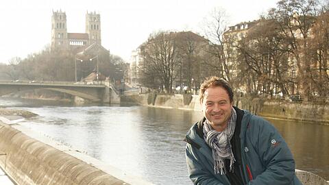 Rainer Maria Schießler und Dogge Bubi auf der Corneliusbrücke. Im Hintergrund St. Maximilian.