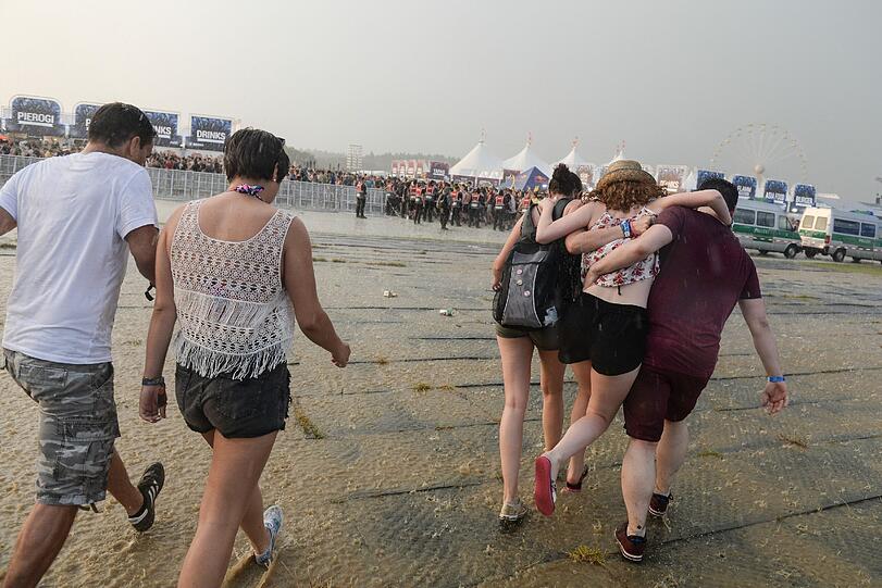 Festivalbesucher verlassen am ersten Tag des "Southside Festivals" wegen einer Unwetterwarnung bei Regen das Festivalgelände.