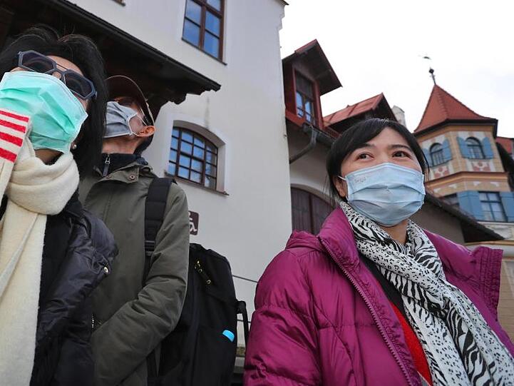 Touristen tragen nahe des Schlosses Neuschwanstein Mundschutz. Foto: Karl-Josef Hildenbrand/dpa/Archiv