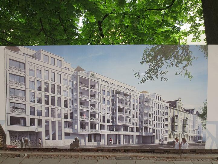 Die Visualisierung, wie die schicken Wohnungen einmal aussehen sollen, ist als Plakat an der Baustelle abgebildet.