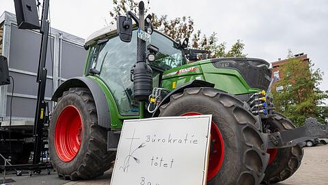 "B&uuml;rokratie t&ouml;tet Bauern" steht auf einem Schild vor einem Traktor bei einer Kundgebung am Rande der Agrarministerkonferenz.