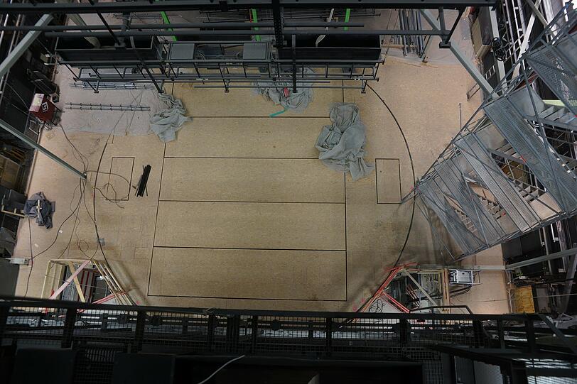 Ein Blick von oben auf die Bühne. Der feine Kreis, den man auf dem Boden sehen kann, ist die Drehbühne. Sie wird trotz Bauarbeiten regelmäßig bewegt, damit die Technik nicht kaputt geht.