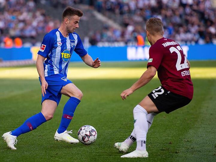 Herthas Klünter (l) liefert sich mit Hannovers Ostrzolek in einem chancenarmen Spiel einen Zweikampf.