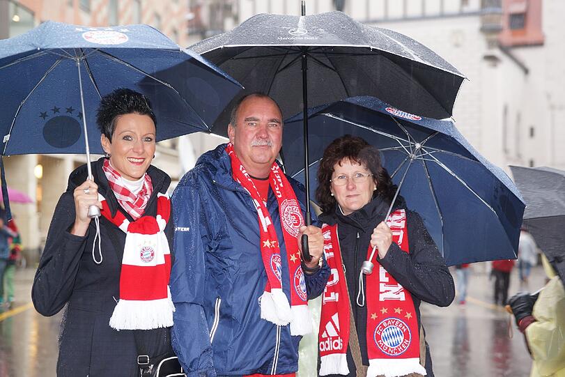 Das lange Warten auf die Pokalhelden. Es regnet und regnet und dennoch warten schon tausende Bayern-Fans auf das Eintreffen der Bayern-Stars. Die Bilder vom Marienplatz