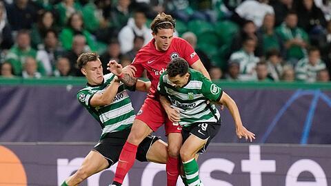 Der Frankfurter Luca Pellegrini (M.) wird von Manuel Ugarte (l) und Pedro Goncalves in die Zange genommen.