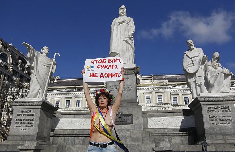 aber auch so sieht "Femen-Protest" aus: Eine 63-Jährige hält ein Schild hoch auf dem übersetzt "Schwieriges Alter" steht.