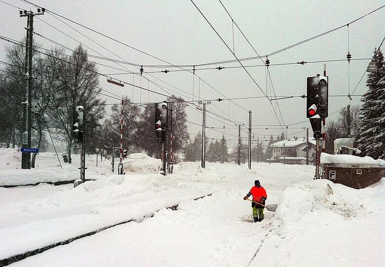 Ein Arbeiter schaufelt auf dem Bahnhof im österreichischen Seefeld (Tirol) den Schnee von den Gleisen.