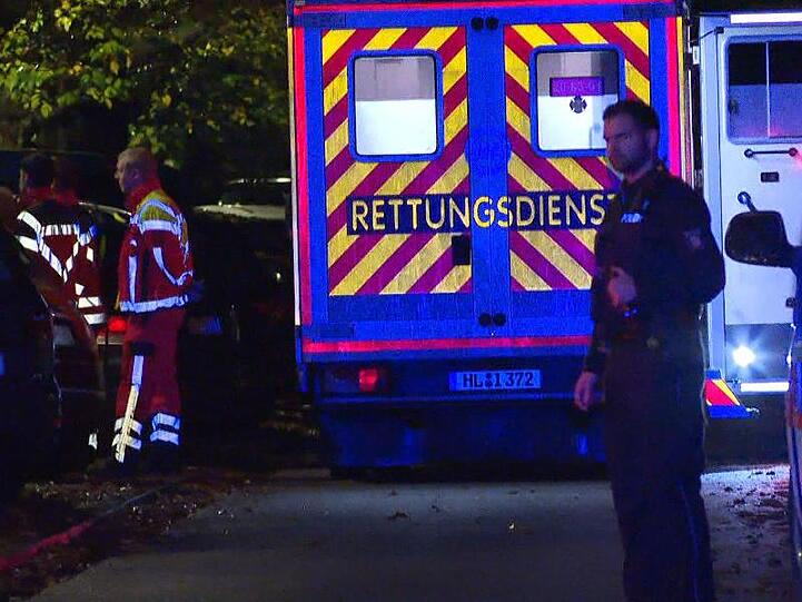 Der Rettungsdienst steht am Einsatzort in Lübeck, wo ein Mann durch Schüsse bei einem Polizeieinsatz gestorben ist.