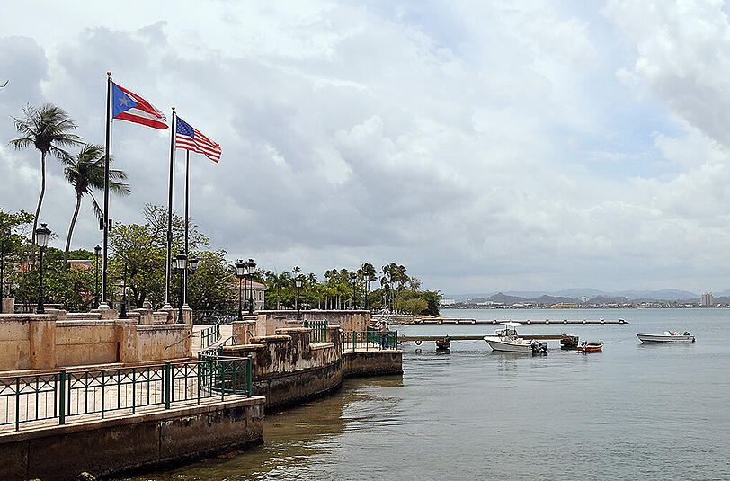 Puerto Ricos Flagge weht neben der US-Flagge an der Altstadt-Promenade von San Juan, Puerto Rico, USA.