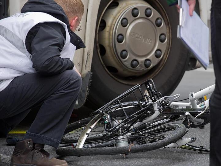 Unter dem Lkw: Polizisten und Gutachter bergen in Berlin ein völlig zertrümmertes Fahrrad.