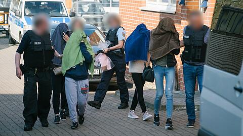 Polizisten führen Frauen aus einem Haus im Stadtteil Anderten. Mit einer groß angelegten Razzia geht die Bundespolizei seit Mittwochmorgen in zwölf Bundesländern gegen Organisierte Kriminalität vor.