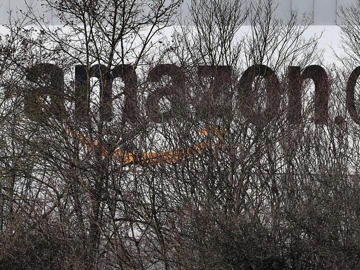 Das Logo des Internethändlers Amazon ist an einem Logistikzentrum angebracht. Foto: Karl-Josef Hildenbrand/Archivbild