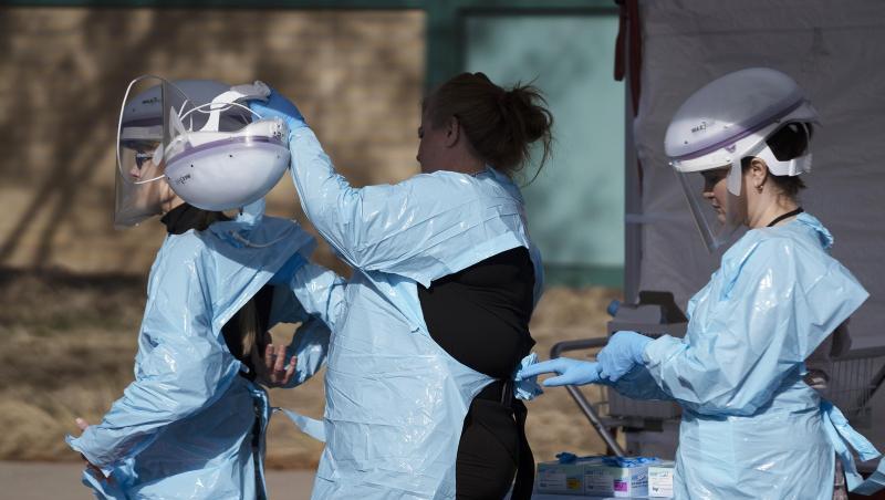 Im Kampf gegen die Lungenkrankheit: Gesundheitsmitarbeiter ziehen ihre Schutzkleidung an, bevor Menschen auf das neue Coronavirus getestet werden. Im Kampf gegen die Lungenkrankheit: Gesundheitsmitarbeiter ziehen ihre Schutzkleidung an, bevor Menschen auf das neue Coronavirus getestet werden.