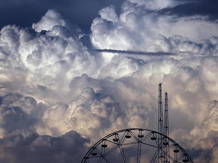 Wolken türmen sich über den Fahrgeschäften des Freizeitparks "Skylinepark" auf. Foto: Karl-Josef Hildenbrand/dpa/Archivbild