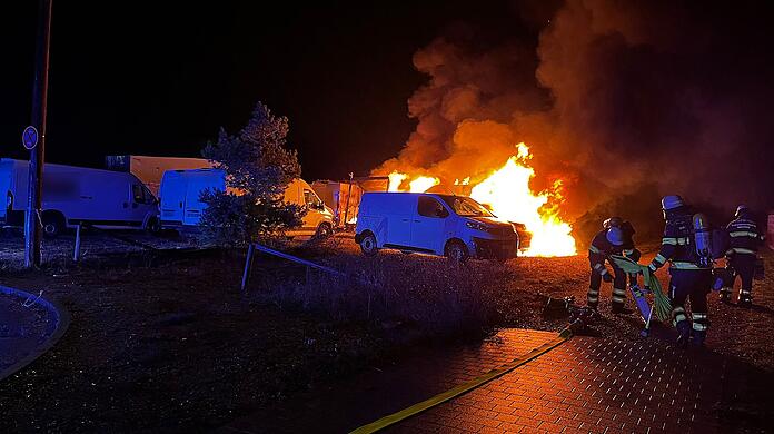 Nach Angaben der Feuerwehr sind vier der acht Kleintransporter komplett ausgebrannt. Die Einsatzkräfte waren eigentlich wegen eines vermeintlichen Zimmerbrands ausgerückt.
