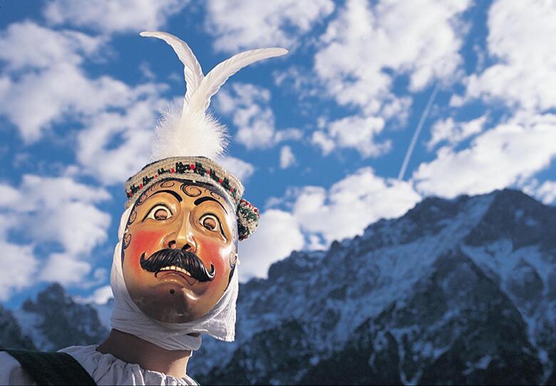 Schellenrührer in Mittenwald

Sie kommen aus einer fernen, alten Welt und treiben ihr Unwesen nur zwischen Unsinnigem Donnerstag und Faschingsdienstag: Da verjagen die Maschkera in Mittenwald mit grausigen Holzlarven lärmend und musizierend die Winterdämonen. Die Jacklschutzer, vier vermummte Gesellen, tragen eine lebensgroße Strohpuppe - den Winter. Er ist nun besiegt, sie werfen ihn mit jubelnden Schreien immer wieder in die Höhe. Höhepunkt des Kehraus ist der Unsinnige Donnerstag, dieses Jahr am 3. März. Dann ziehen die Schellenrührer mit zwölf Kuhglocken um die Hüfte durch den Ort. Raunzend und stampfend fallen sie in eine Gaststätte ein und greifen sich ein Mädchen zum Tanzen. Falls sie keines vorfinden, sagen sie schon mal einem Einheimischen mit spöttischen Sprüchen die Meinung - und sind dann schnell wieder weg.