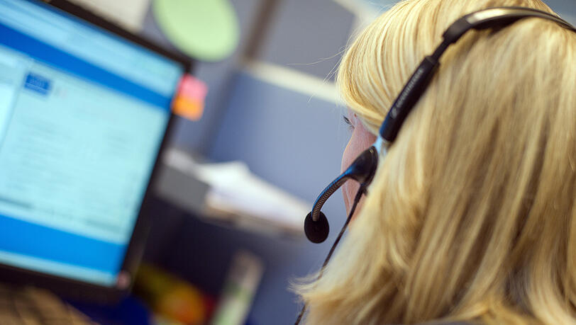 Eine Mitarbeiterin sitzt vor einem Computermonitor mit Headset. Als Internetanbieter braucht Telef&oacute;nica Deutschland einen gro&szlig;en telefonischen Kundenservice-Bereich.
