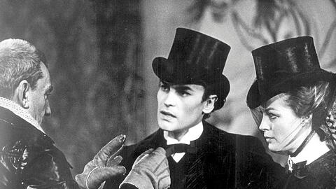 Der Schauspieler Helmut Berger (Mitte) während der Dreharbeiten in der Rolle des exzentrischen bayerischen Märchenkönigs "Ludwig II." in dem gleichnamigen Film des italienischen Regisseurs Luchino Visconti (l.) - rechts Romy Schneider als "Sisi - Elisabeth von Österreich"
