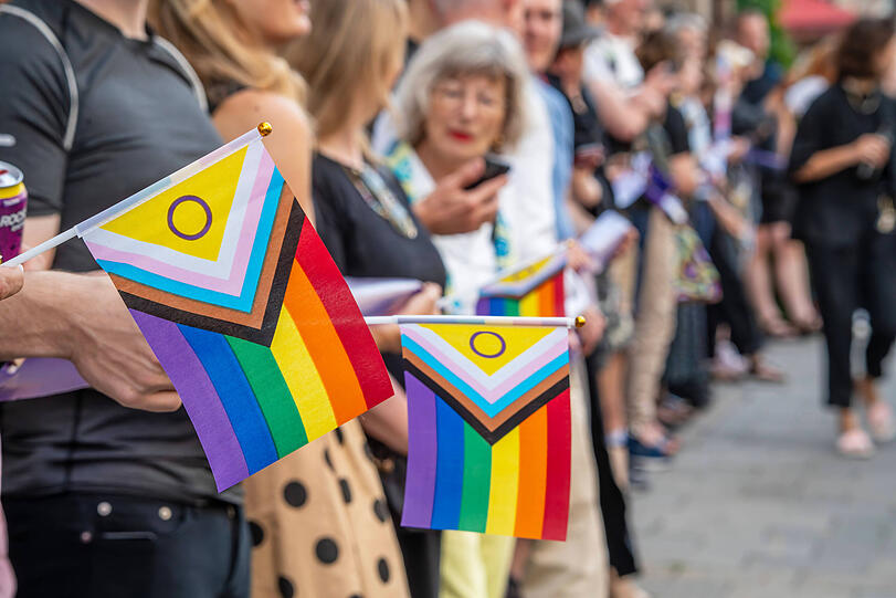 Queere Demo mit Menschenkette: Regenbogenfahnen