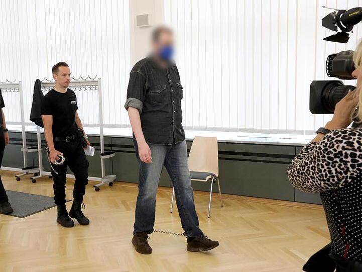 Justizmitarbeiter führen den 39-Jährigen in den Saal des Rostocker Landgerichts.