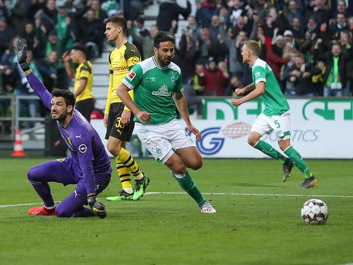Bremens Torschütze Claudio Pizarro (M) hat den Treffer zum 2:2 erzielt während BVB-Torwart Roman Bürki (l) reklamiert.