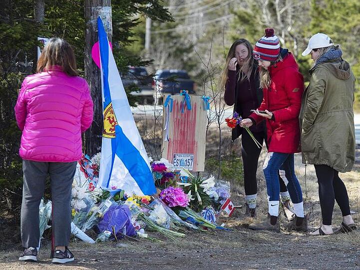 Frauen legen Blumen an einer Gedenkstätte für die Opfer des Amoklaufs in Nova Scotia ab. Als Reaktion auf die schlimme Bluttat hat Kanada die Waffengesetze verschärft.