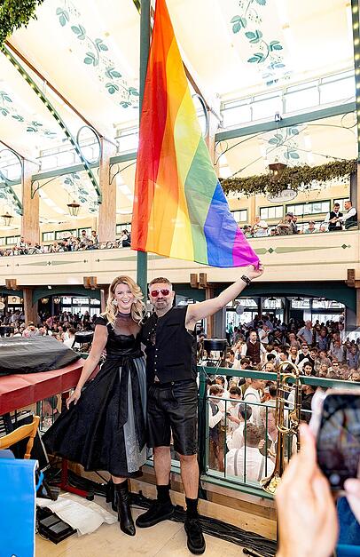 Wiesn-Wirtin Franziska Kohlpaintner hisst mit Designer Adrian Runhof die Regenbogenflagge in der Bräurosl.
