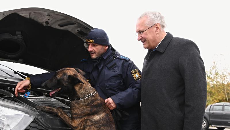 Innenminister Joachim Herrmann (CSU, r) mit einem Polizeibeamten und Hund Max bei einer Kontrolle. Foto: Nicolas Armer/dpa Innenminister Joachim Herrmann (CSU, r) mit einem Polizeibeamten und Hund Max bei einer Kontrolle. Foto: Nicolas Armer/dpa