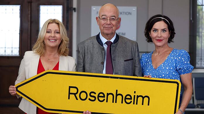 Karin Thaler (l.), Alexander Duda (M.) und Marisa Burger (r.) stehen für "Die Rosenheim-Cops" zusammen vor der Kamera.