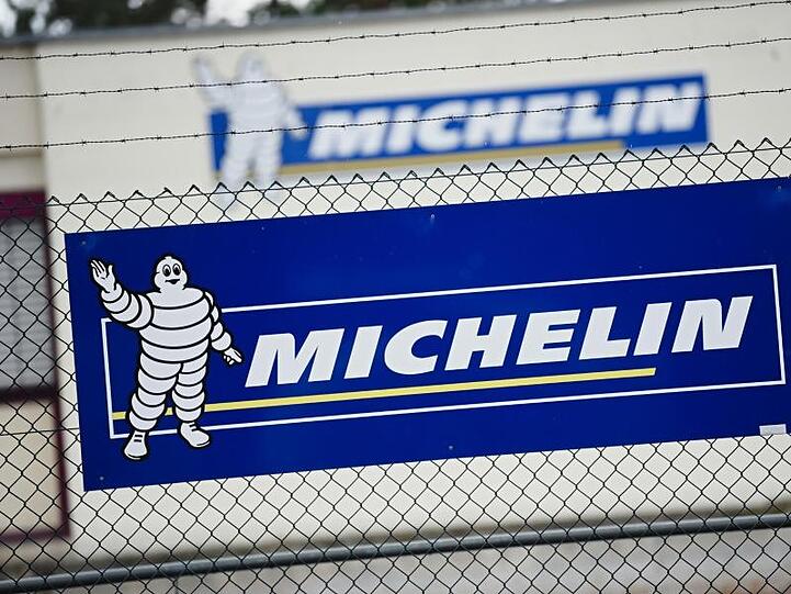 Vor dem Michelin-Werk in Hallstadt ist ein Banner mit dem Firmenlogo an einem Zaun zu sehen. Foto: Nicolas Armer/dpa/Archivbild