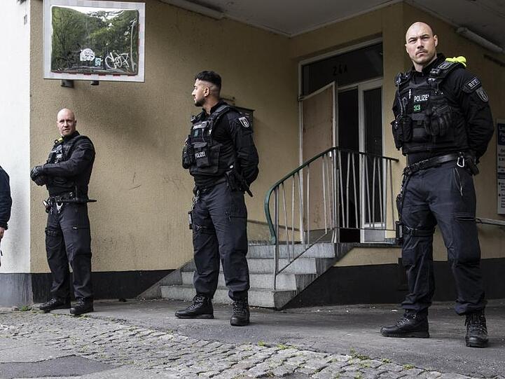 Polizeibeamte stehen im Rahmen einer Razzia auf der Mecklenburgischen Straße in Berlin.