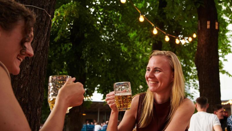 Zwei Frauen trinken ein Bier im Prater Biergarten in Berlin.