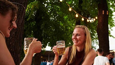 Zwei Frauen trinken ein Bier im Prater Biergarten in Berlin.