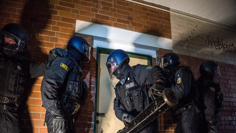 Beamten der Bundespolizei öffnen mit einer Ramme die Tür zur Wohnung eines Verdächtigen.(Symbolbild)