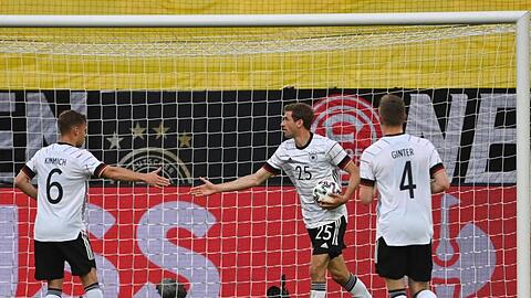 Thomas M&uuml;ller (M.) holt nach seinem Tor zum 3:0 den Ball aus dem Netz.