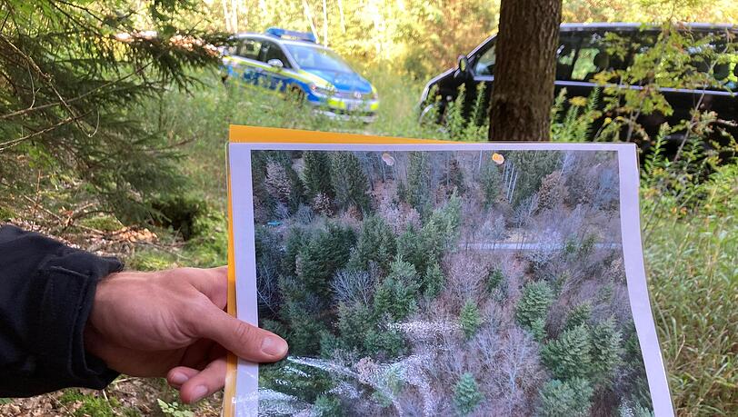 Ein Polizeibeamter hält bei der Suche ein Drohnen-Bild in der Hand. Ein Polizeibeamter hält bei der Suche ein Drohnen-Bild in der Hand.