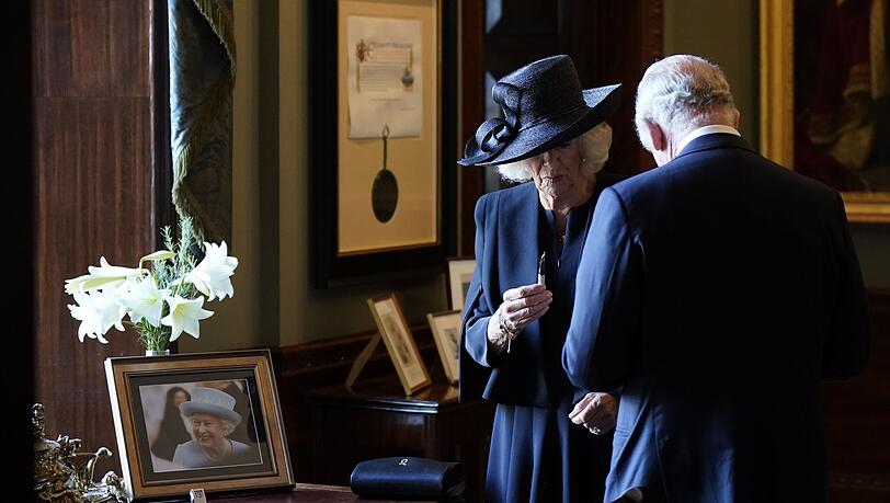 Königin Camilla hält einen Füllfederhalter, während sich König Charles III. Tinte von der Hand wischt. Der Monarch wollte sich in Hillsborough Castle in ein Gästebuch eintragen, als der Stift zu schmieren begann.